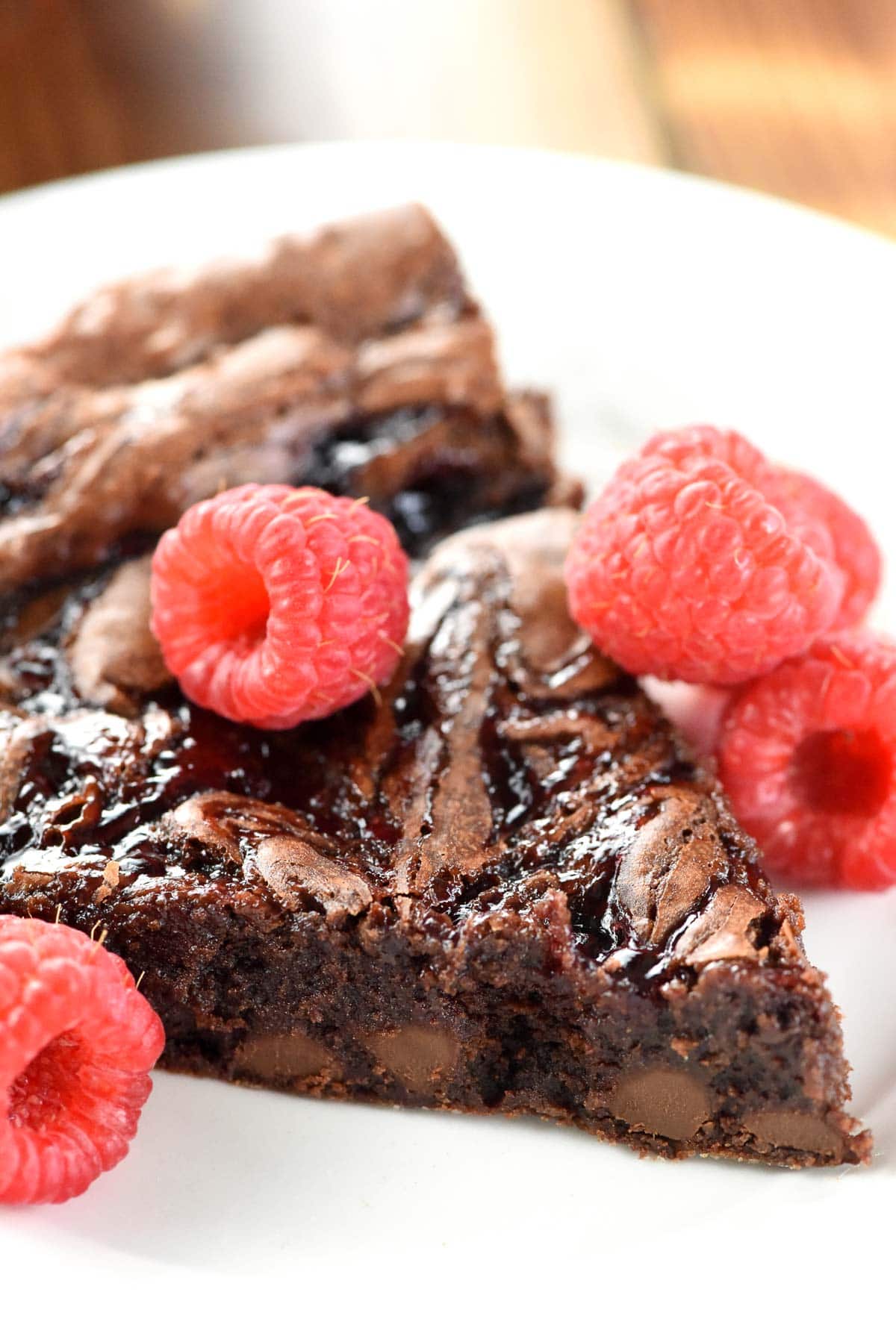 Close-up of homemade brownies with raspberries on top.