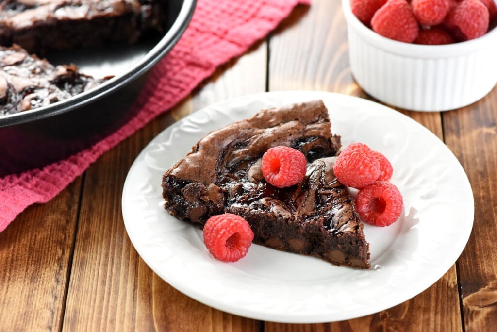 Raspberry brownies on plate with berries.