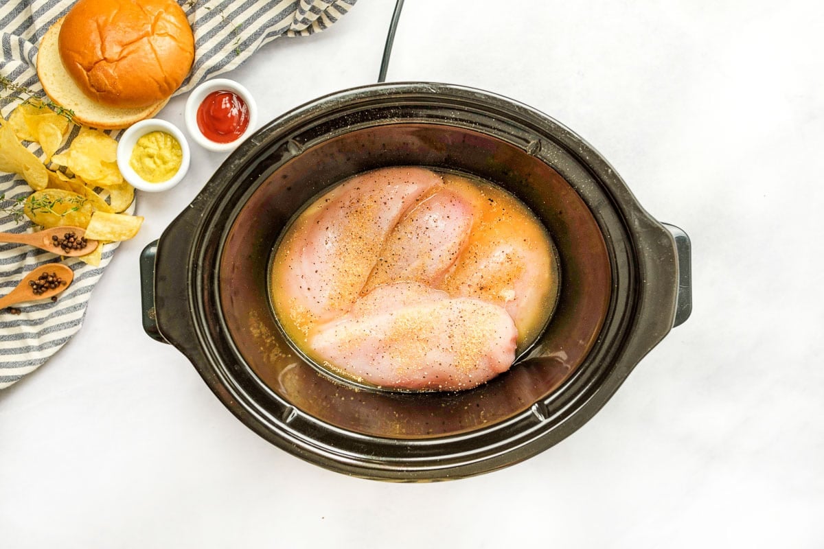 Chicken breasts, broth, and seasonings in the crock pot.