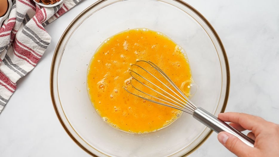 Whisking eggs in glass bowl.