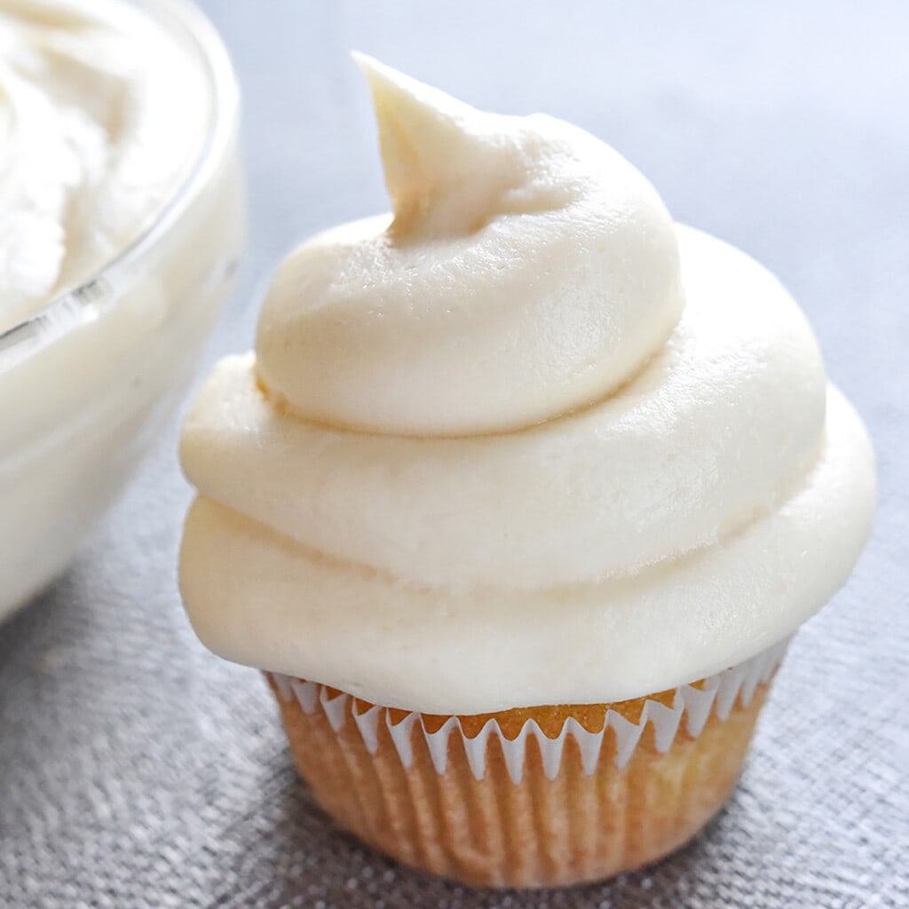 Cream Cheese Frosting on vanilla cupcake and in glass bowl.