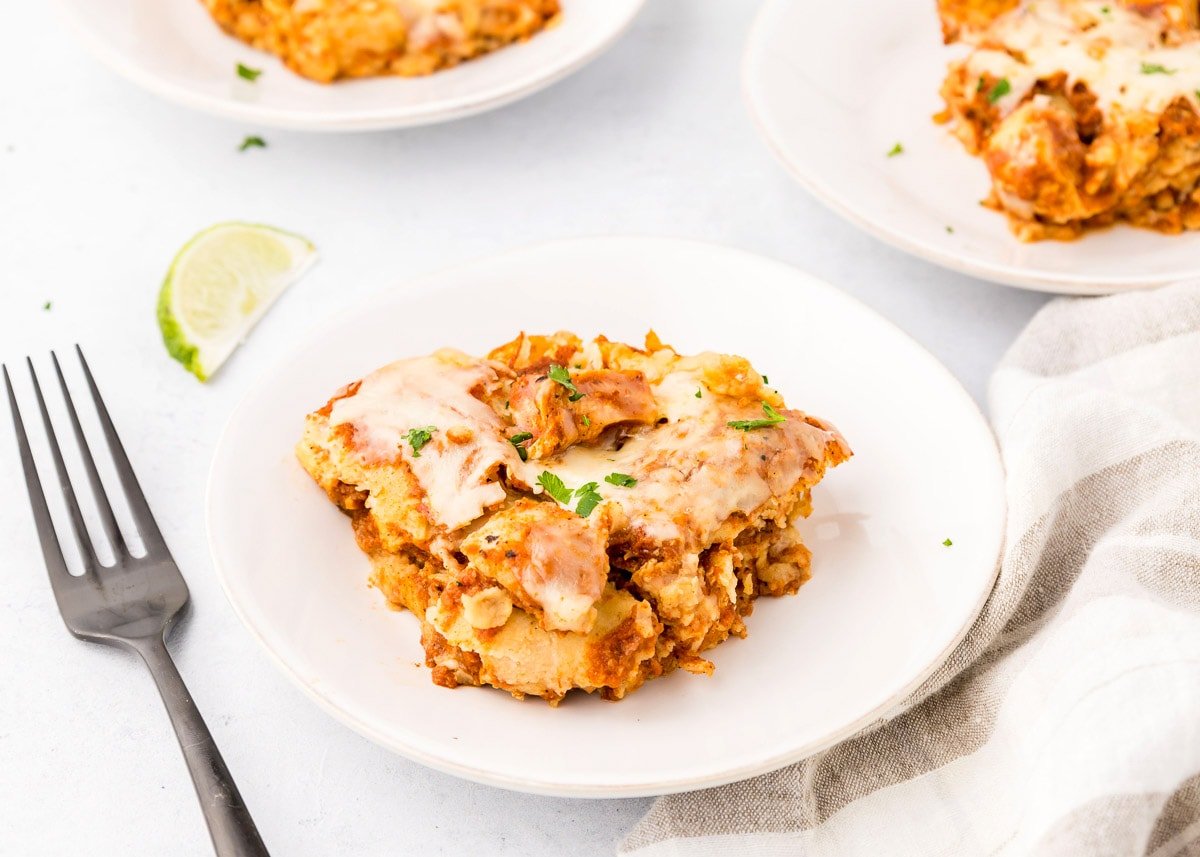 Crock Pot Chicken Enchiladas recipe on plate with fork.