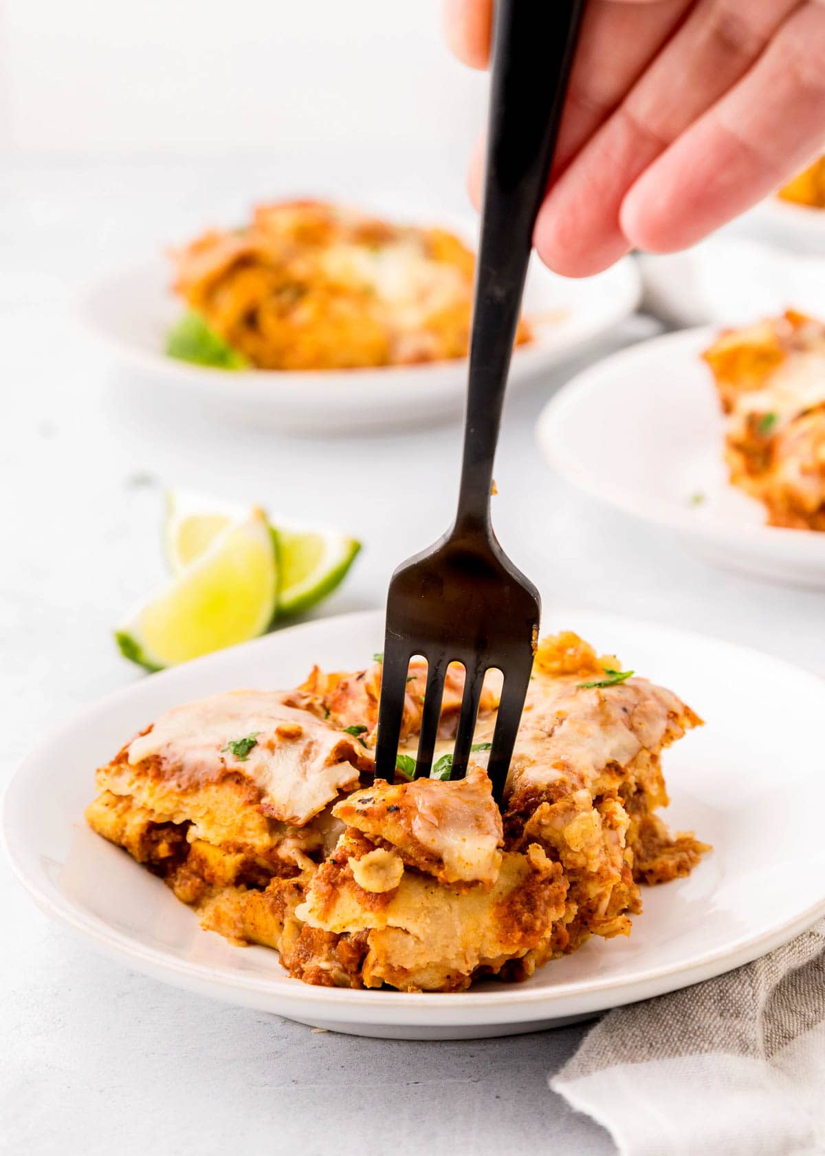 Fork cutting into Crock Pot Chicken Enchiladas.