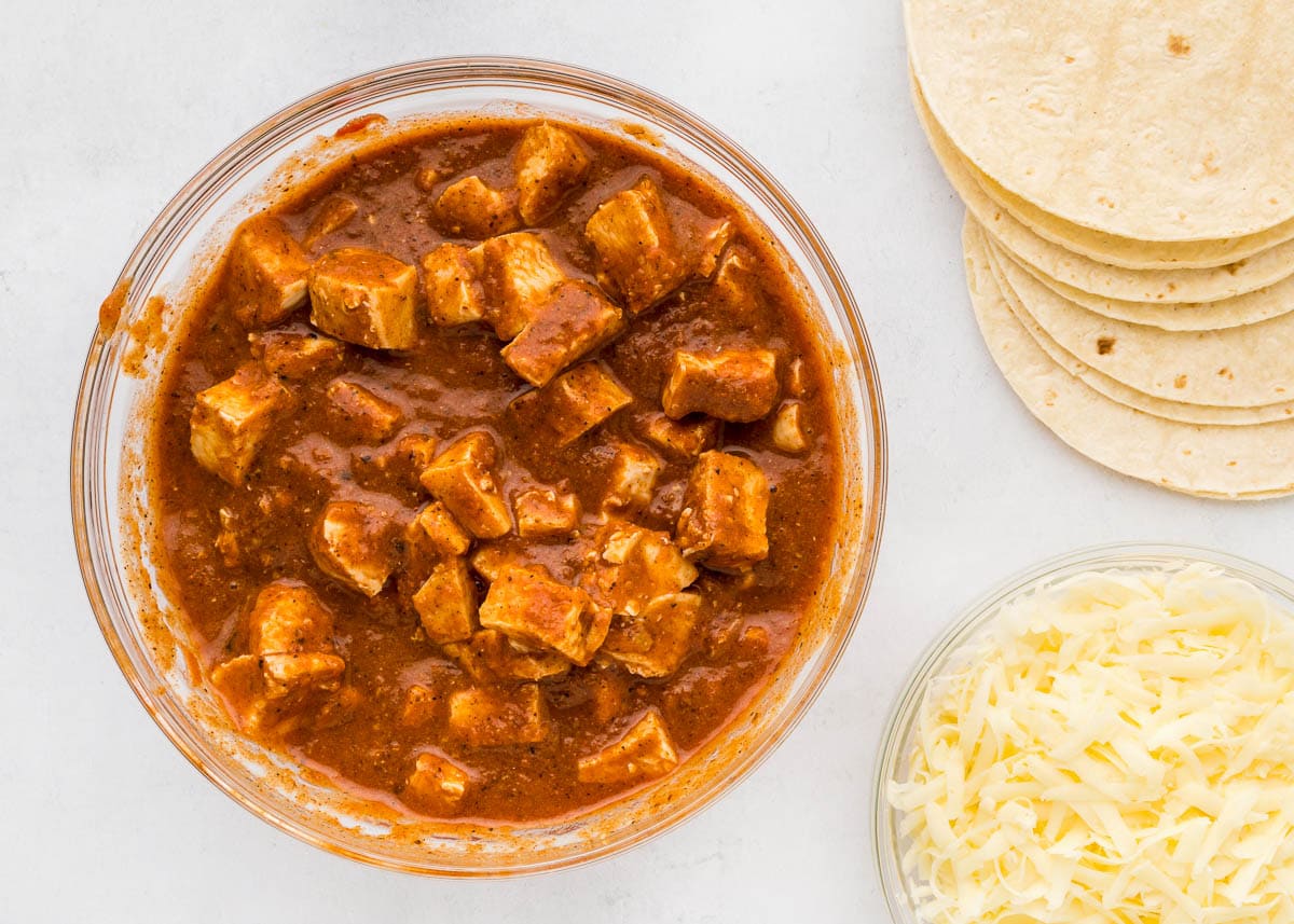 Chicken in sauce for slow cooker chicken enchiladas.