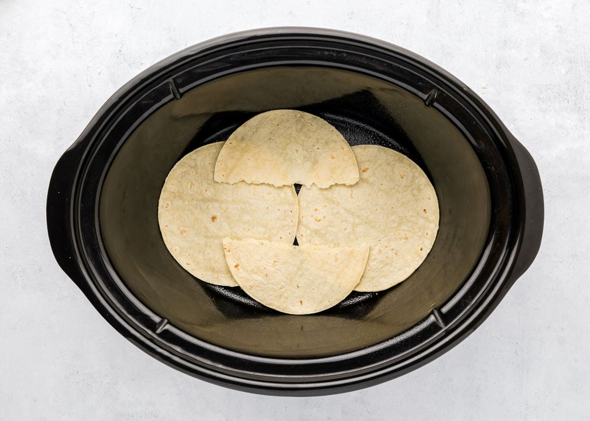 Tortillas in the bottom of slow cooker.