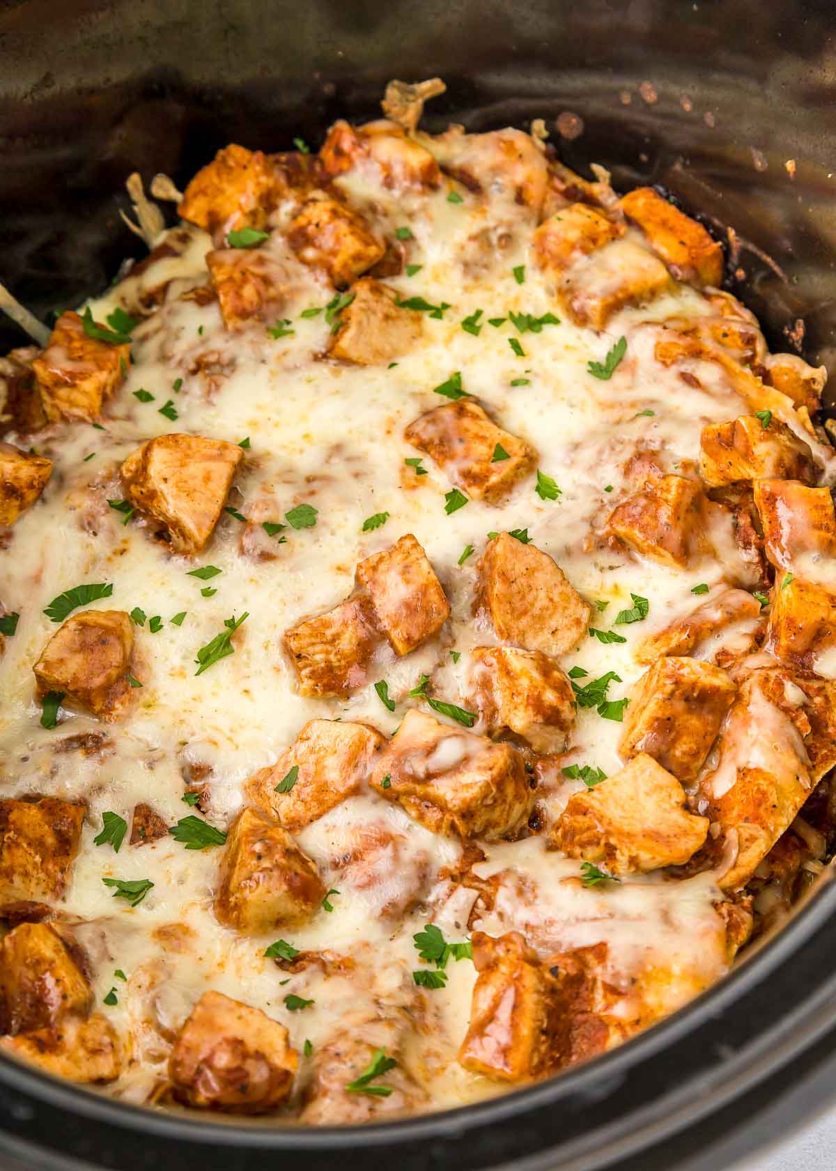 Close-up of Crock Pot Chicken Enchiladas in slow cooker.