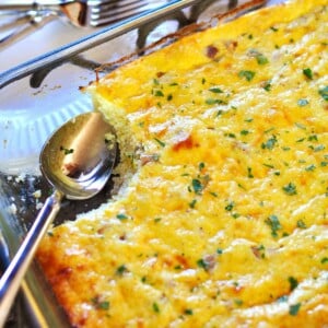 Grits Casserole in dish with spoon and missing serving.