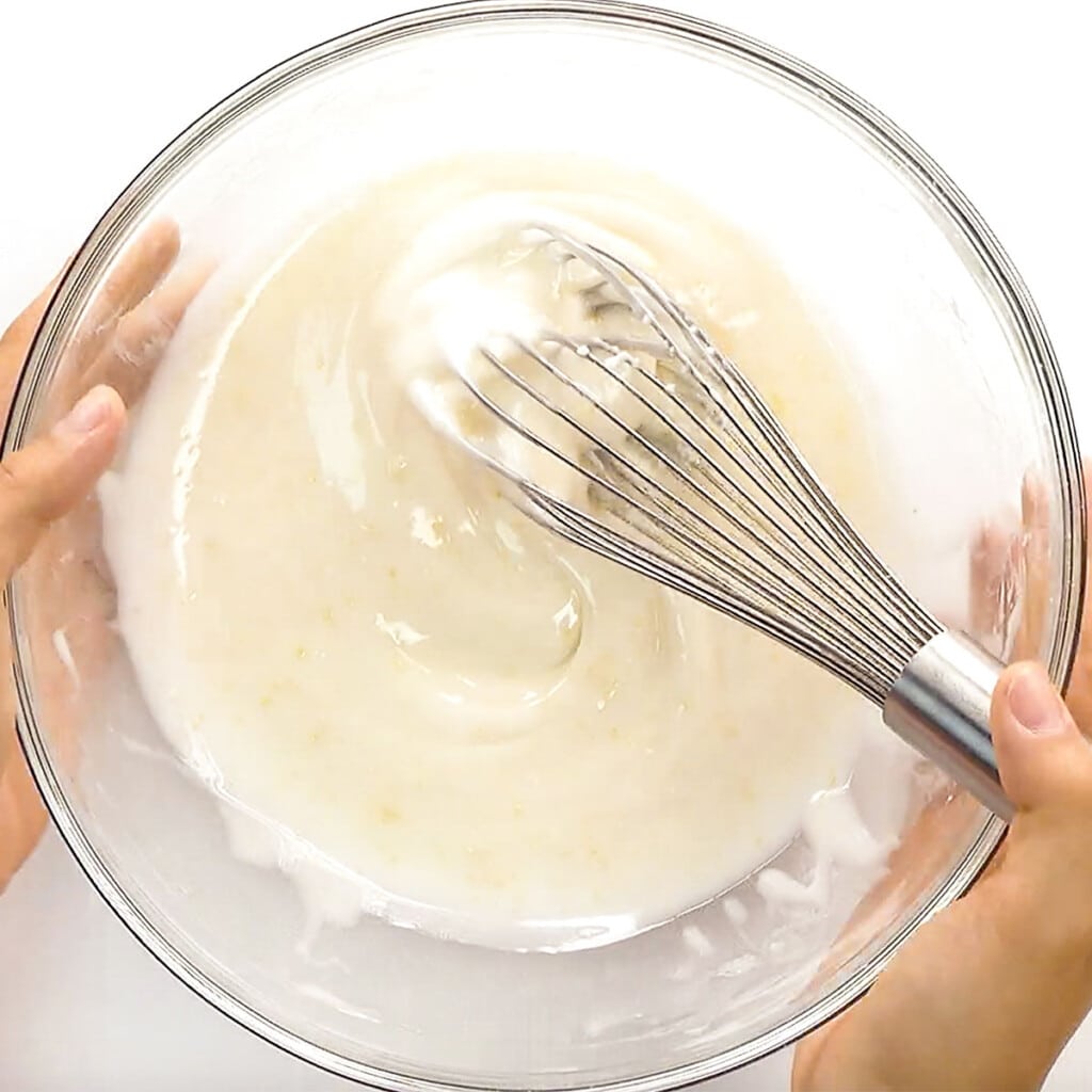 Whisking lemon glaze recipe in bowl.