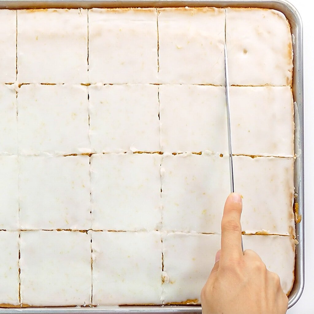 Slicing best lemon cake recipe: Lemon Sheet Cake.