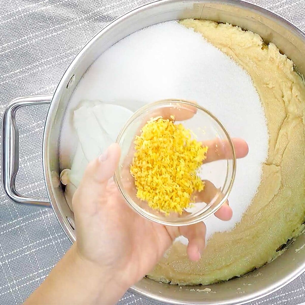 Adding sugar, sour cream, and lemon zest to lemon cake recipe.