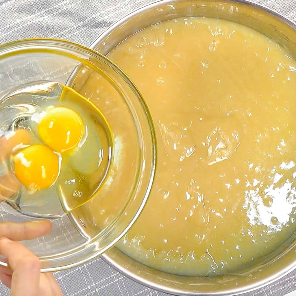 Adding eggs to batter.