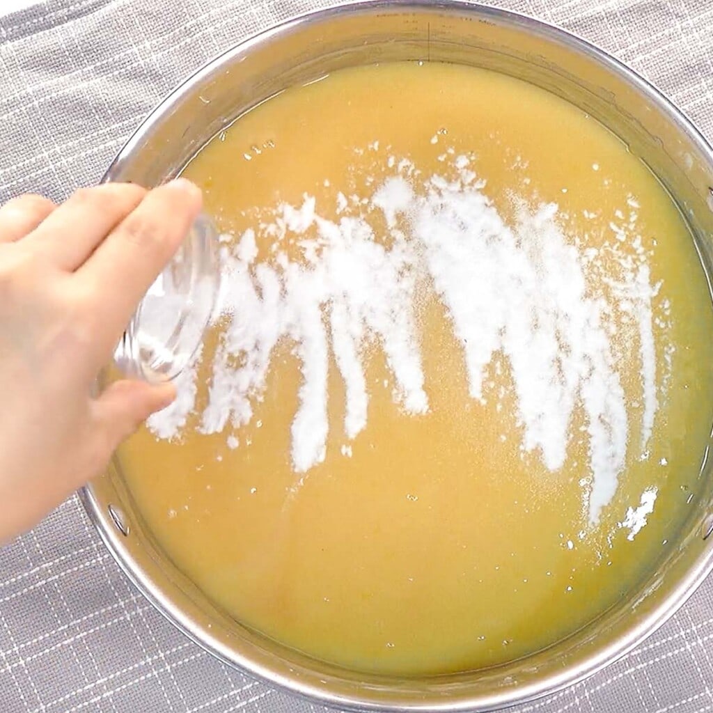 Adding baking powder and salt to lemon cake batter.