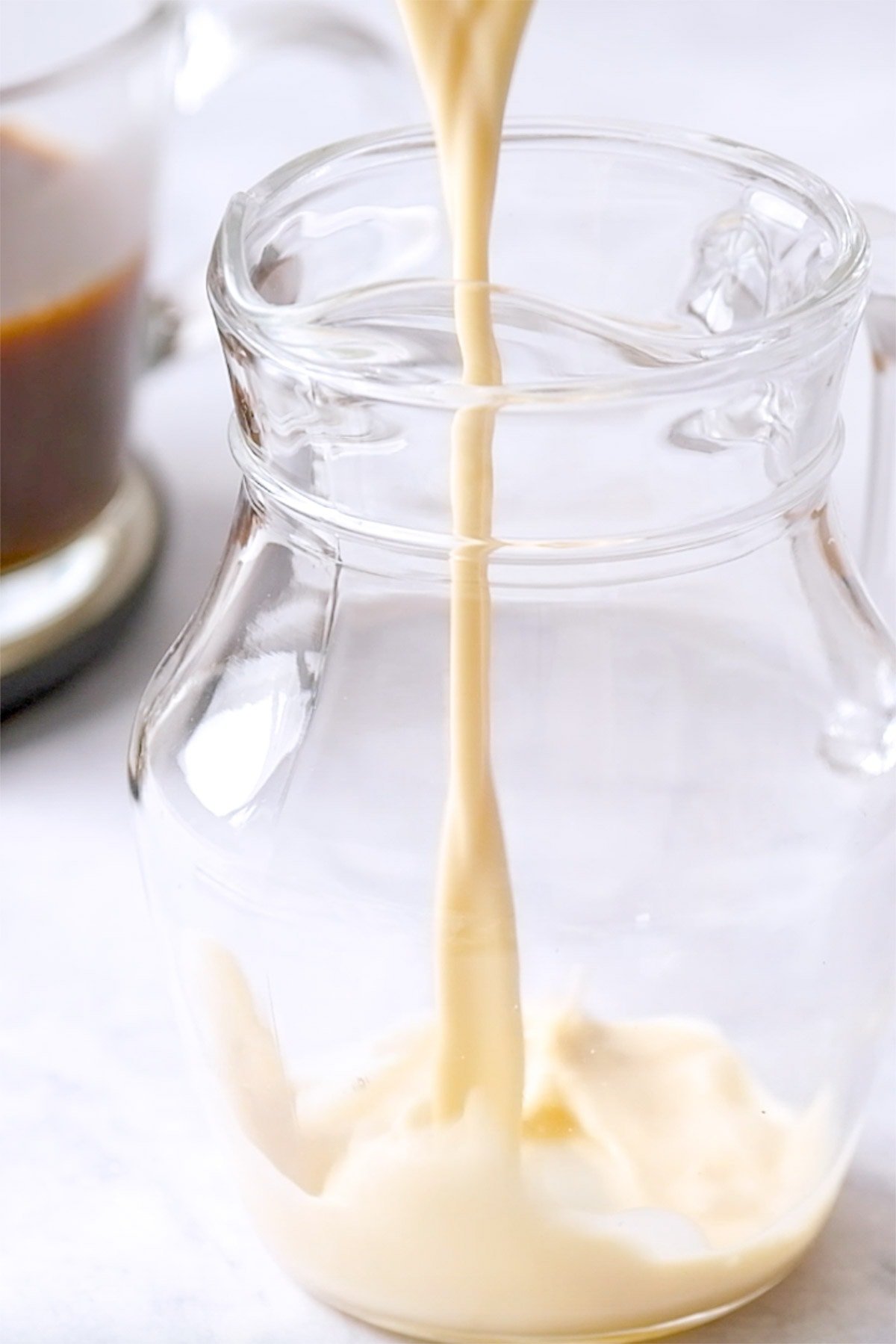 Pouring Vanilla Coffee Creamer into glass pitcher.