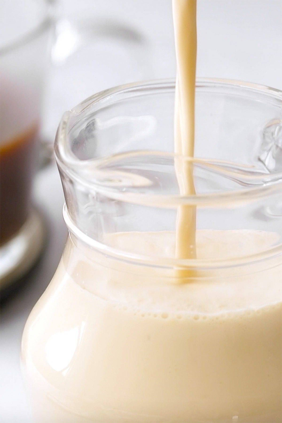 Close-up of Vanilla Coffee Creamer streaming into glass container.