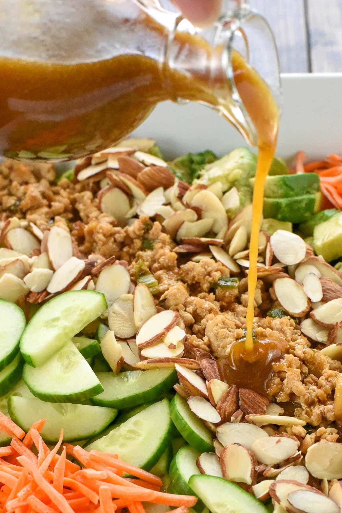 Pouring Asian Salad Dressing recipe over salad.