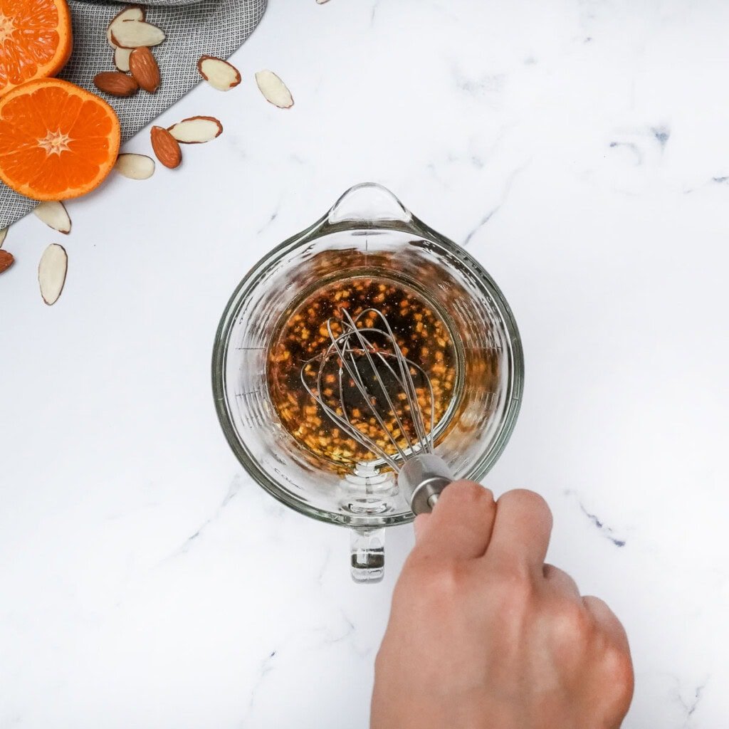 Whisking sesame ginger vinaigrette.