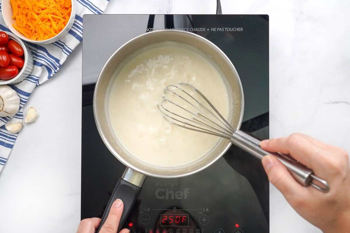 Whisking milk into roux.