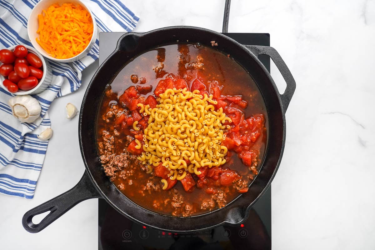 How to make homemade hamburger helper by coming cooked ground beef, spices, diced tomatoes, and elbow pasta.