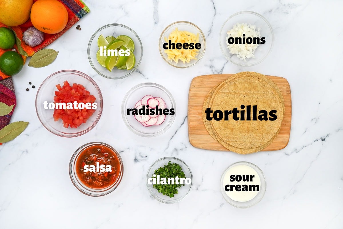 Labeled ingredients to build carnitas tacos.
