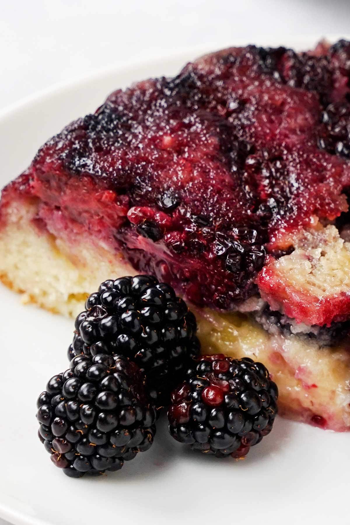 Close-up of Blackberry Cake with three fresh blackberries.