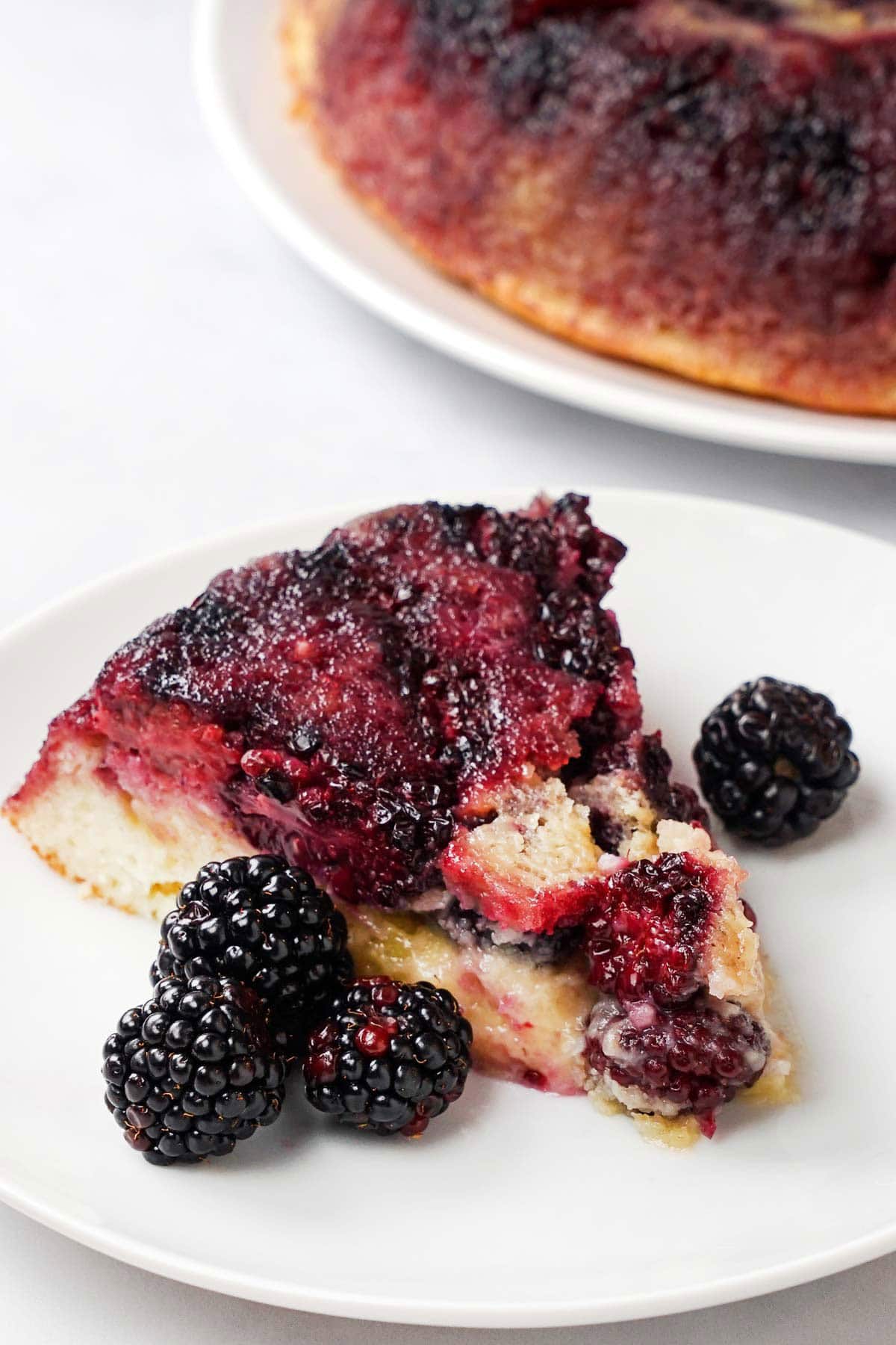 Blackberry Cake on plate with fresh berries.