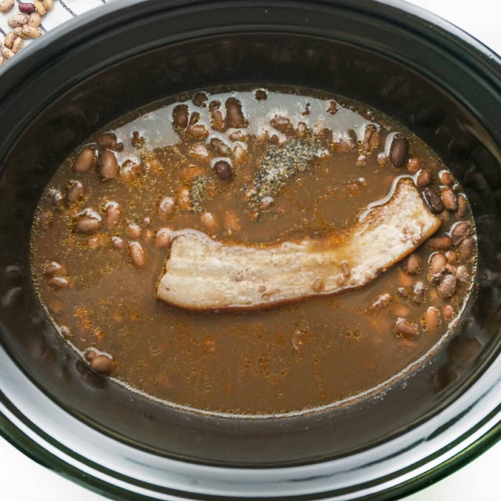 Ranch Style Beans in slow cooker with salt and pepper.