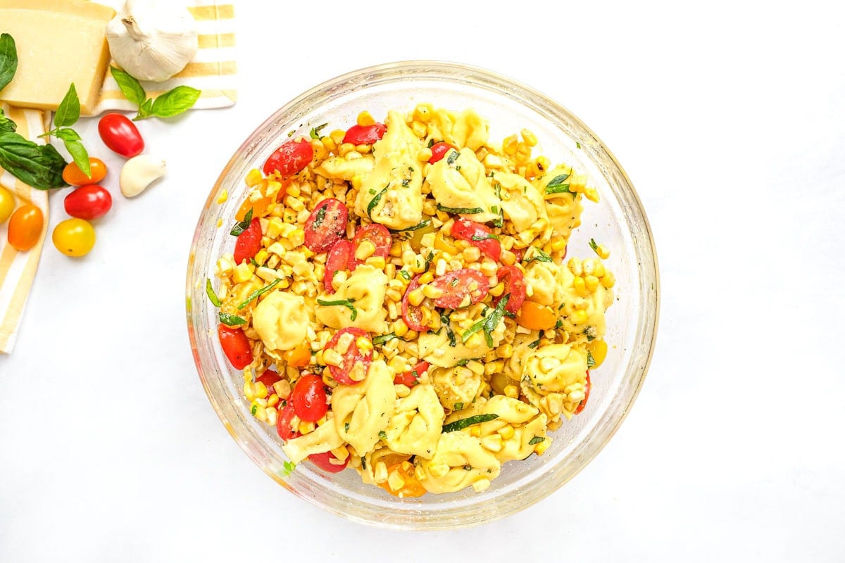 Cheese tortellini pasta salad in glass bowl.