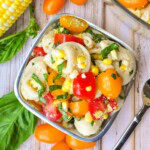 Tortellini Pasta Salad in pewter bowl with corn, basil, and tomatoes.