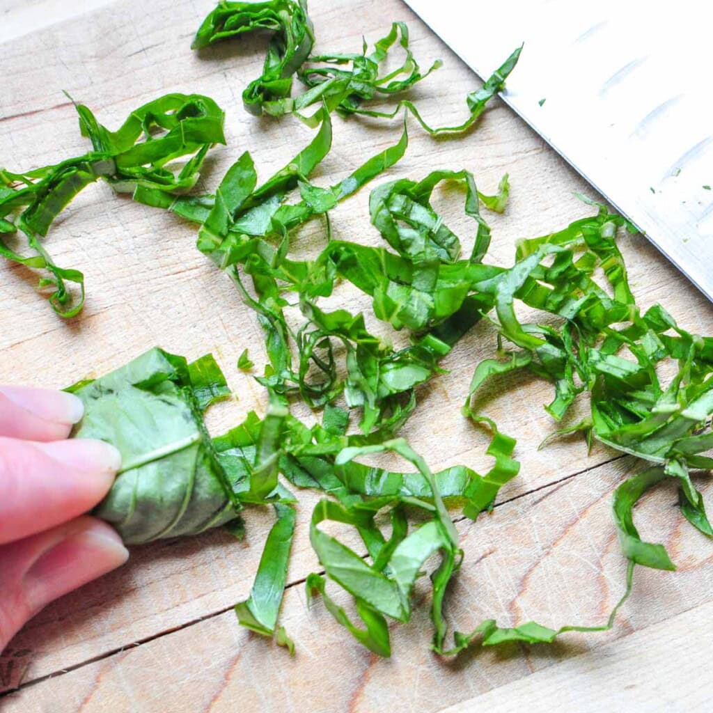 Basil chiffonade for cheese tortellini pasta salad.