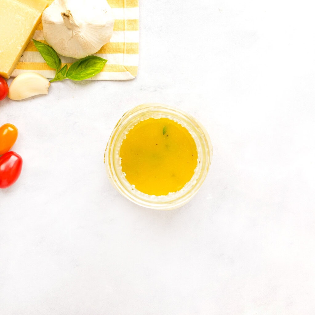 Parmesan basil vinaigrette shaken in jar for tortellini salad.