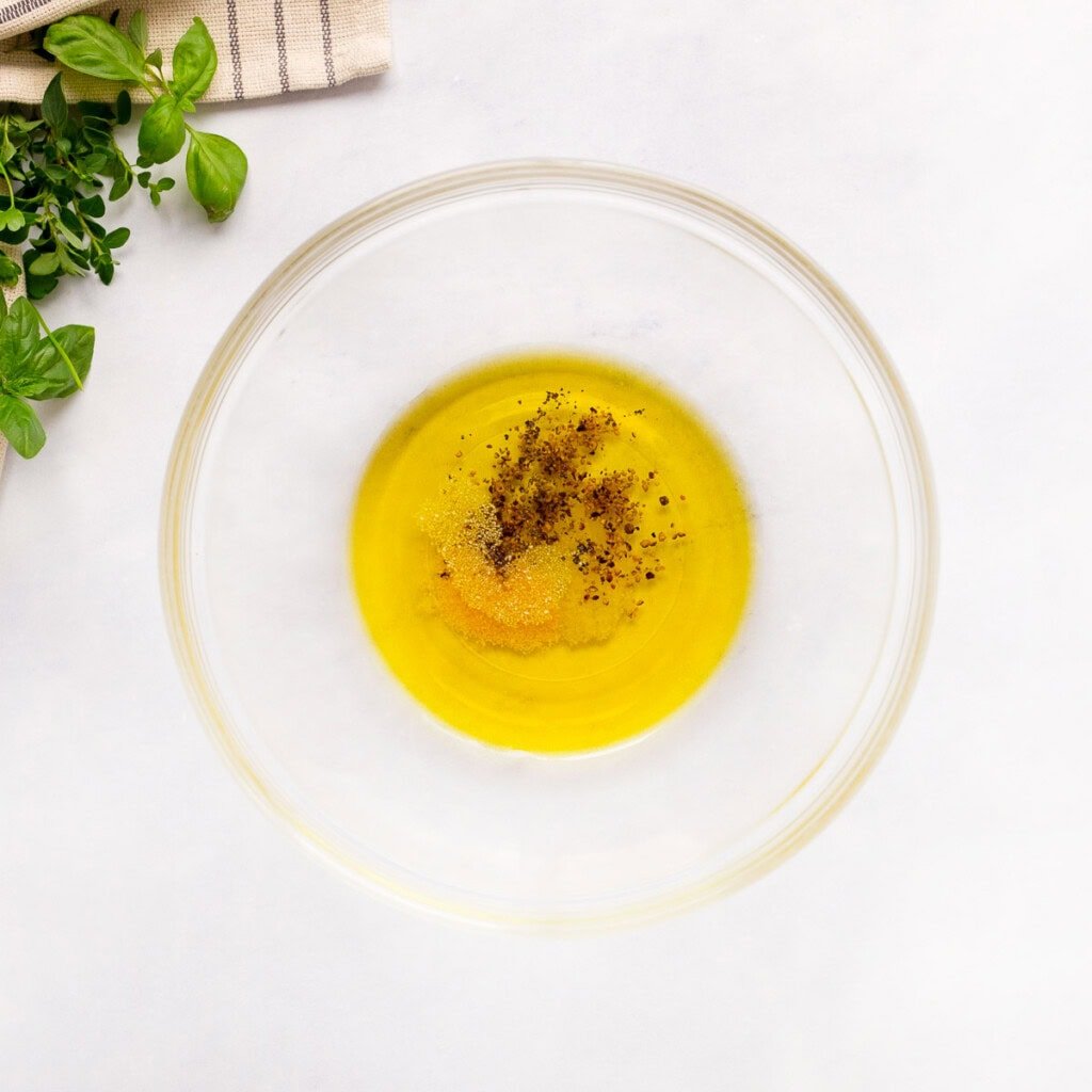 Bowl of olive oil and seasonings for Italian baked chicken.
