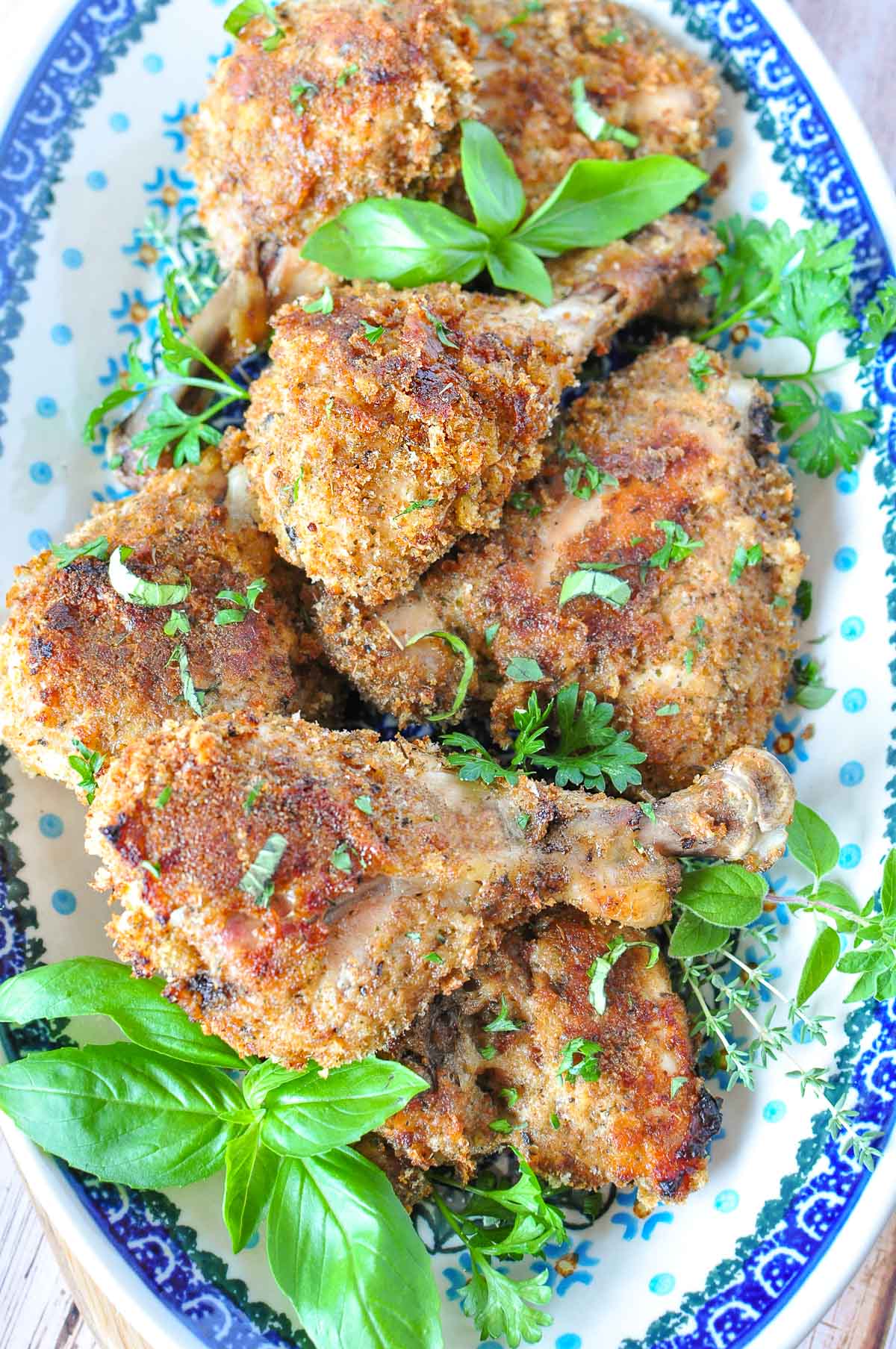 Baked Italian Chicken on platter with fresh herbs.