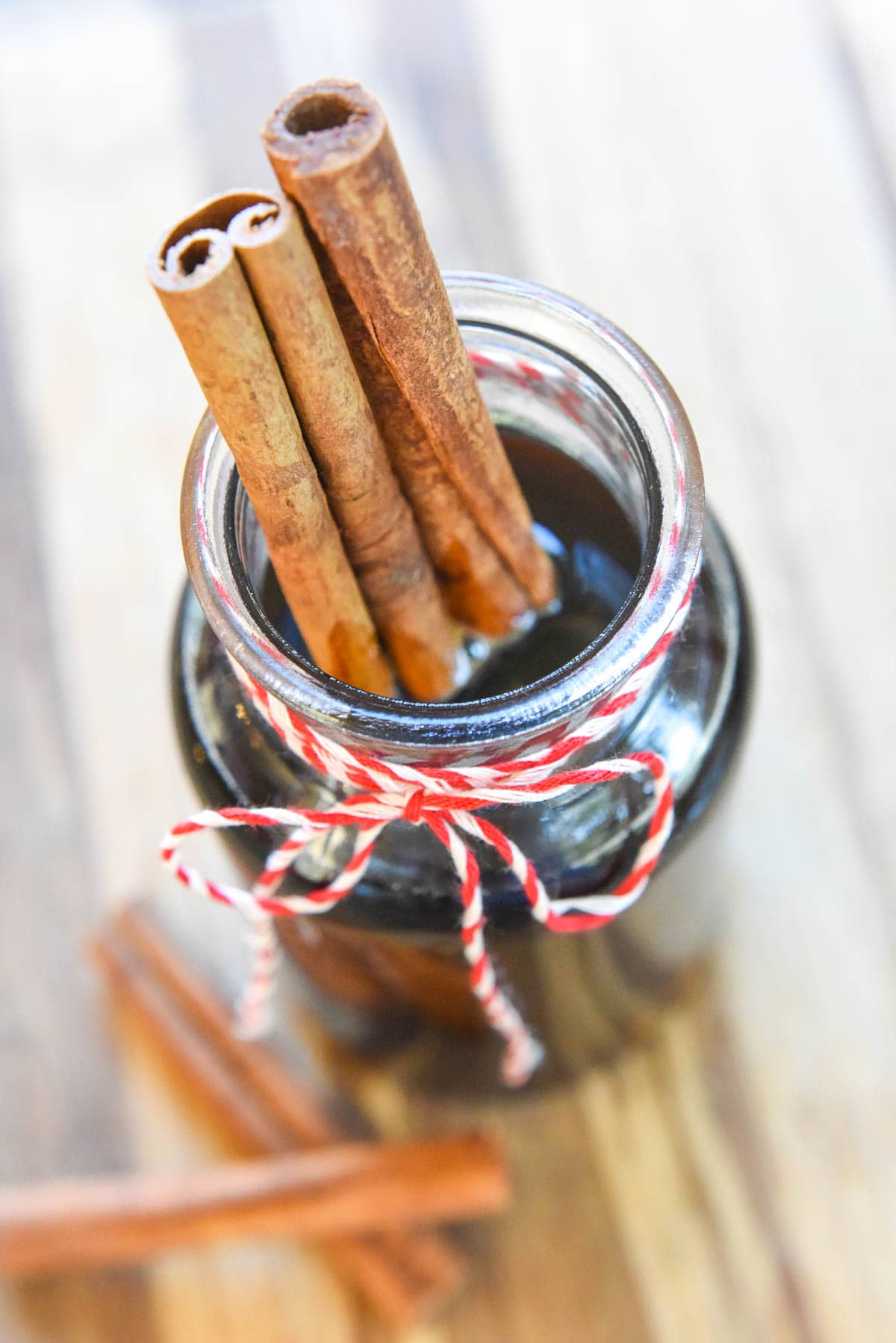 Cinnamon Dolce Syrup in jar with cinnamon sticks.