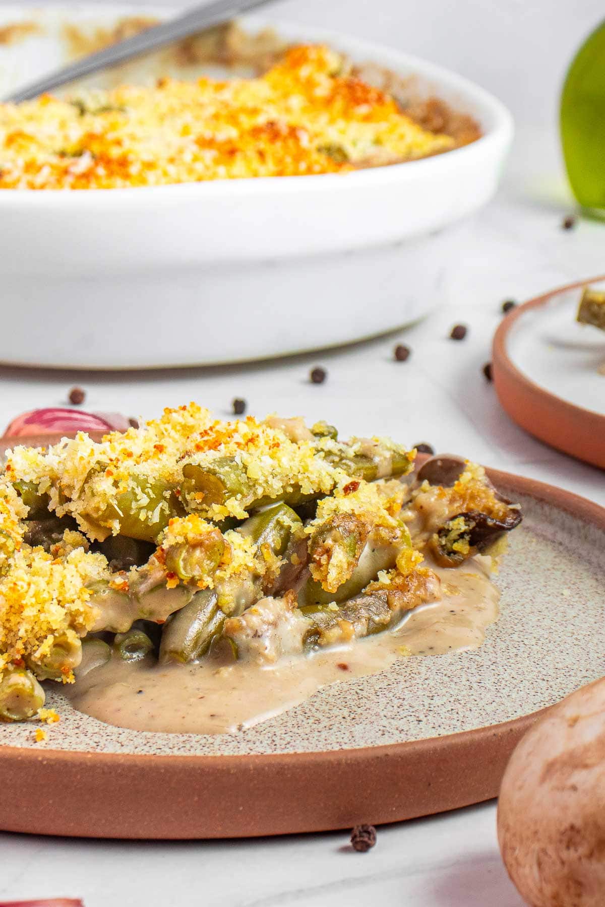 Green Bean Casserole From Scratch on plate with baking dish in background.