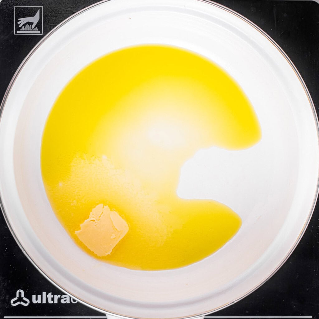 Melting butter in pot to make homemade mushroom sauce.
