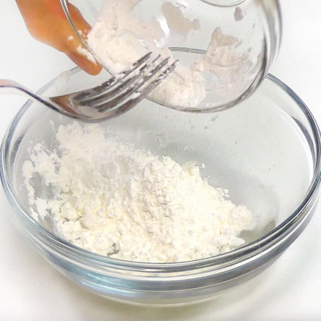 Adding cornstarch to water in bowl.