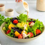 Chipotle Ranch poured over salad in bowl.