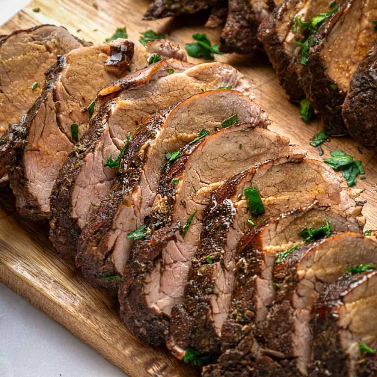 Pork Tenderloin Marinade drizzled over sliced pork on board.