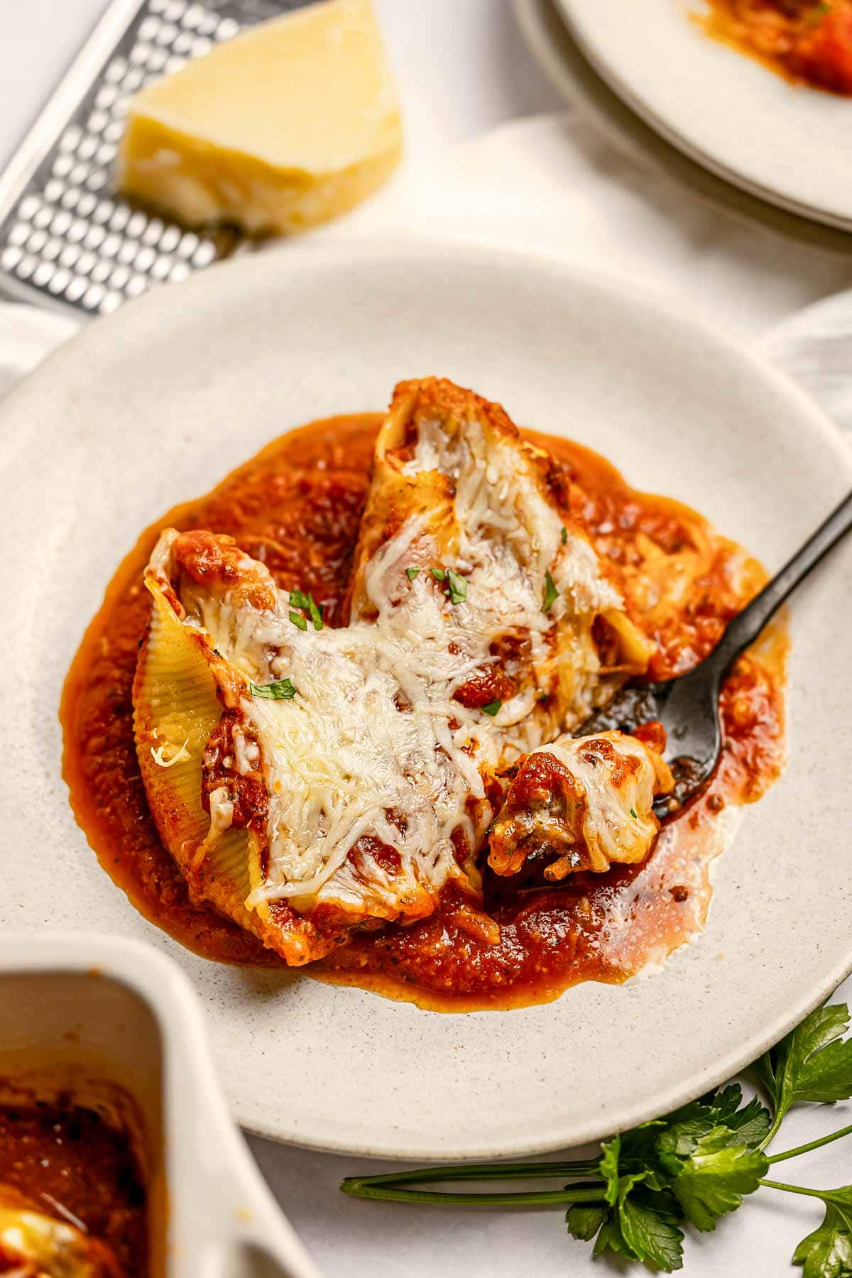 Stuffed Shells with Meat aerial close-up of plate with Parmesan.