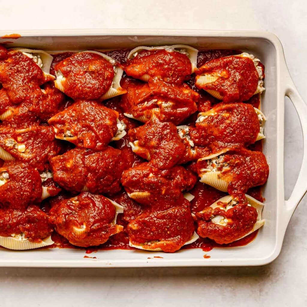 Stuffed shells with ricotta and meat topped with sauce.