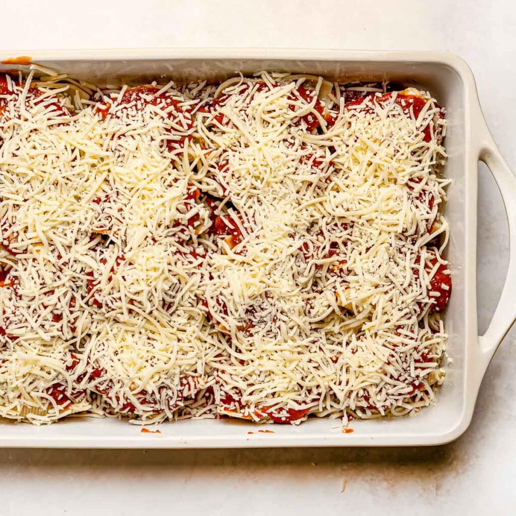 Stuffed shells recipe with meat topped with cheese and ready for the oven.