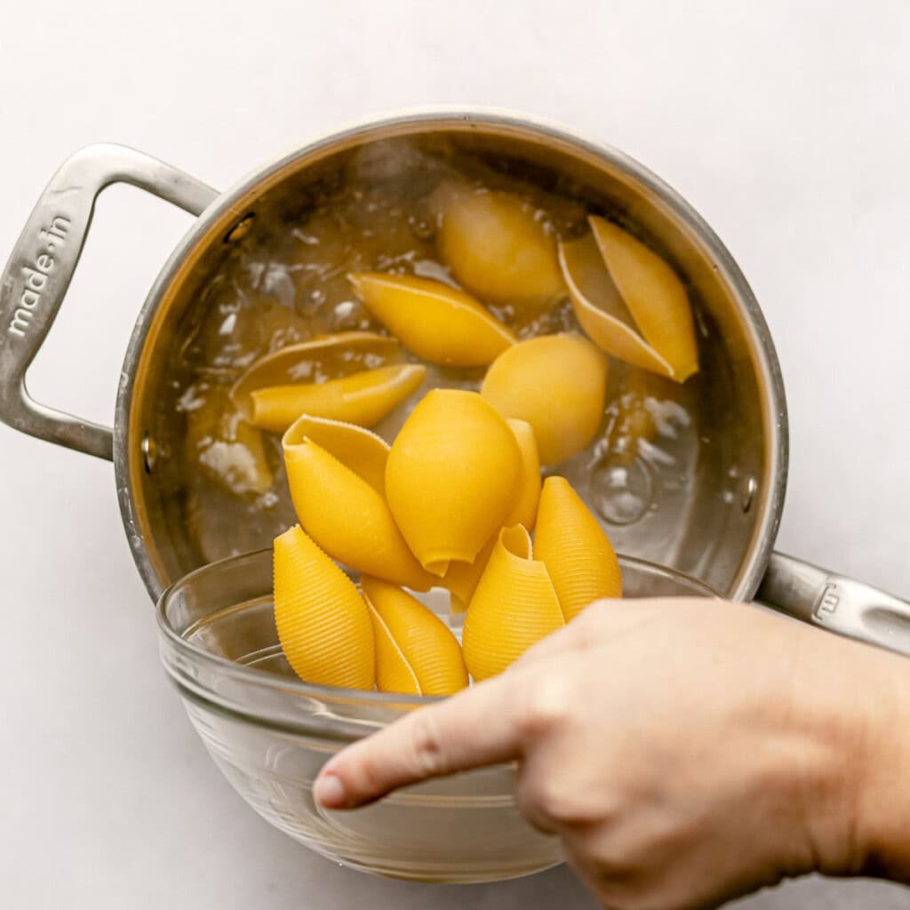 Putting pasta in boiling water.