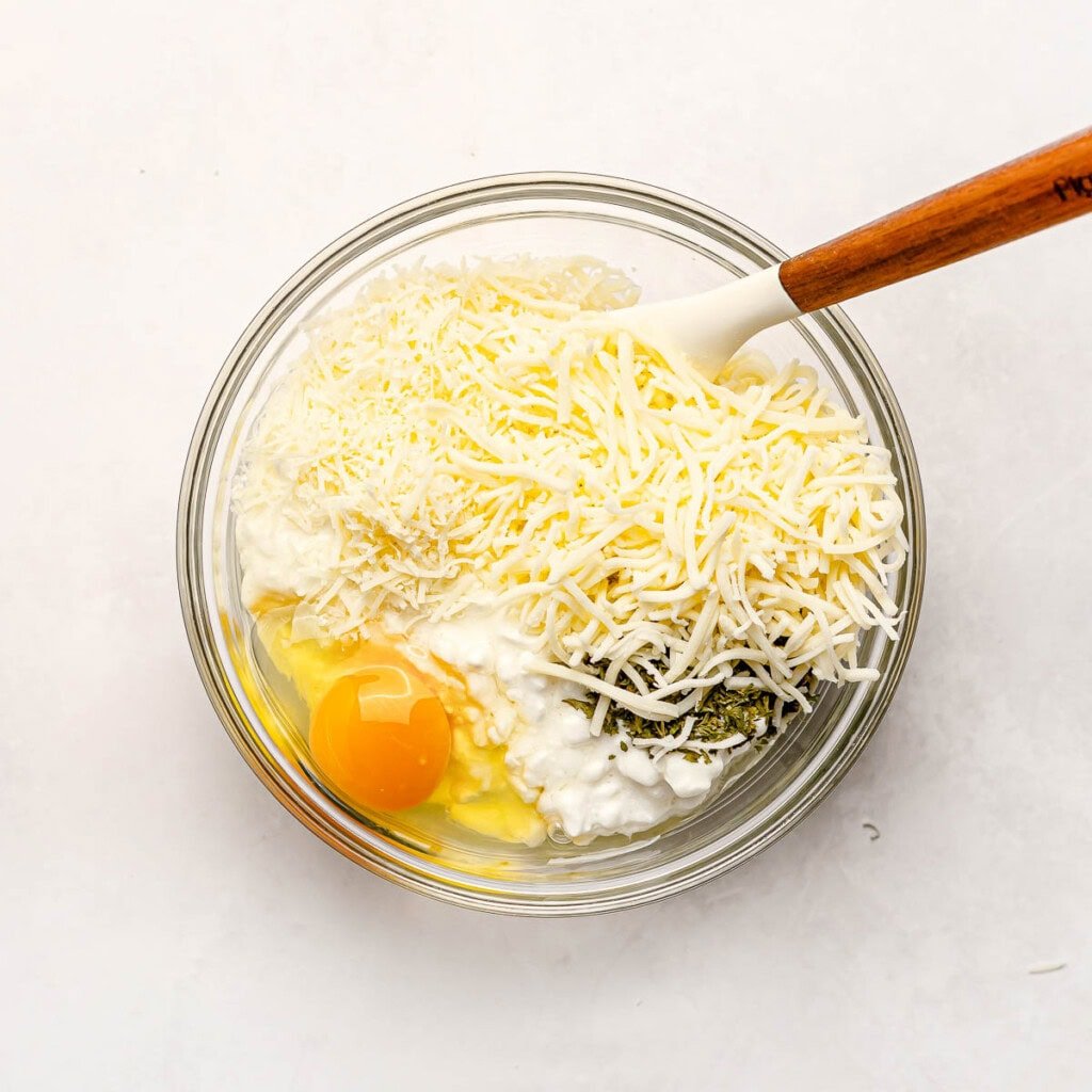 Ingredients in bowl for stuffed shells with ricotta and meat.