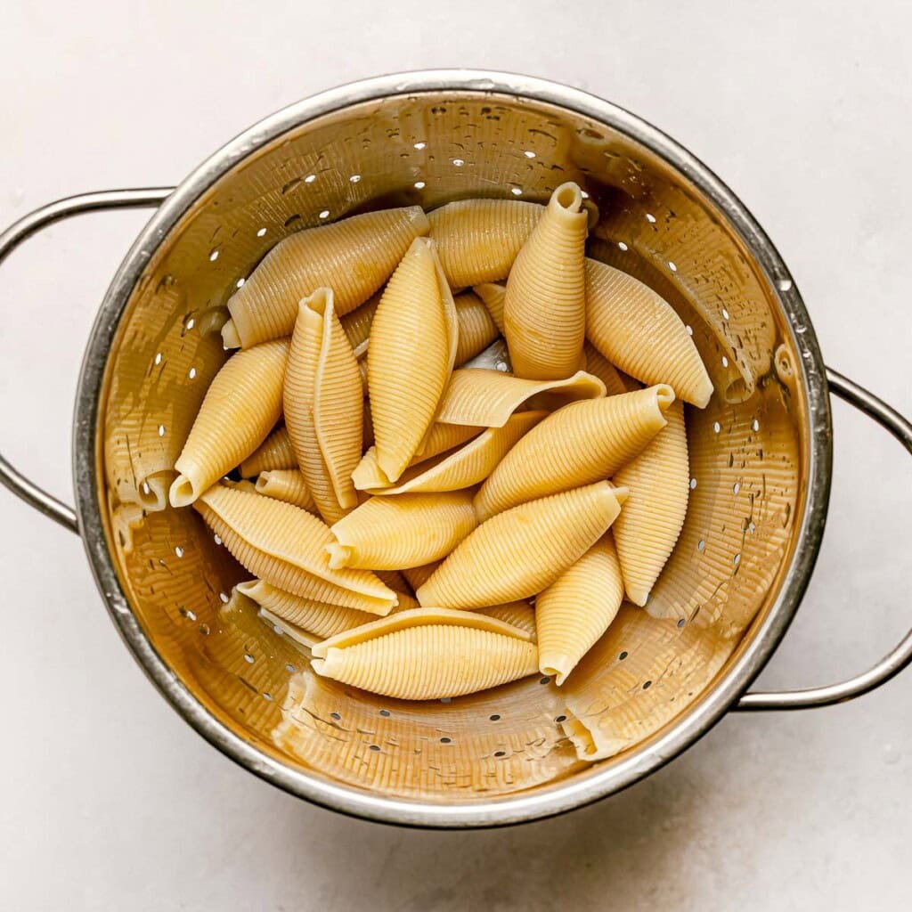 Drained pasta for Stuffed Shells with Meat.