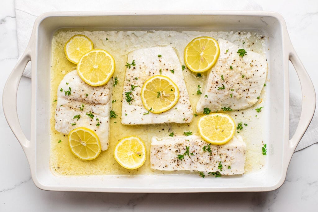 Baked Halibut with lemon garlic butter in baking dish fresh out of oven.