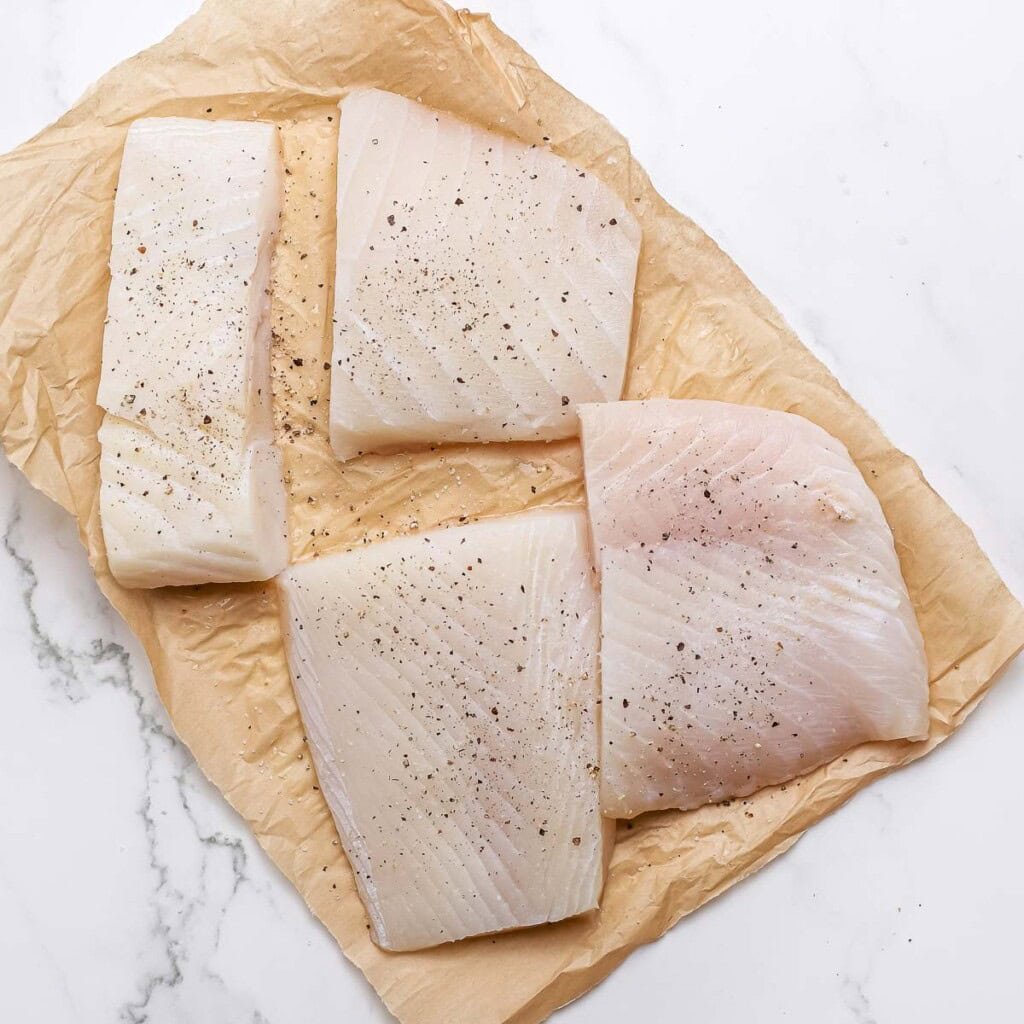 Seasoned filets laid out for baked halibut recipes.