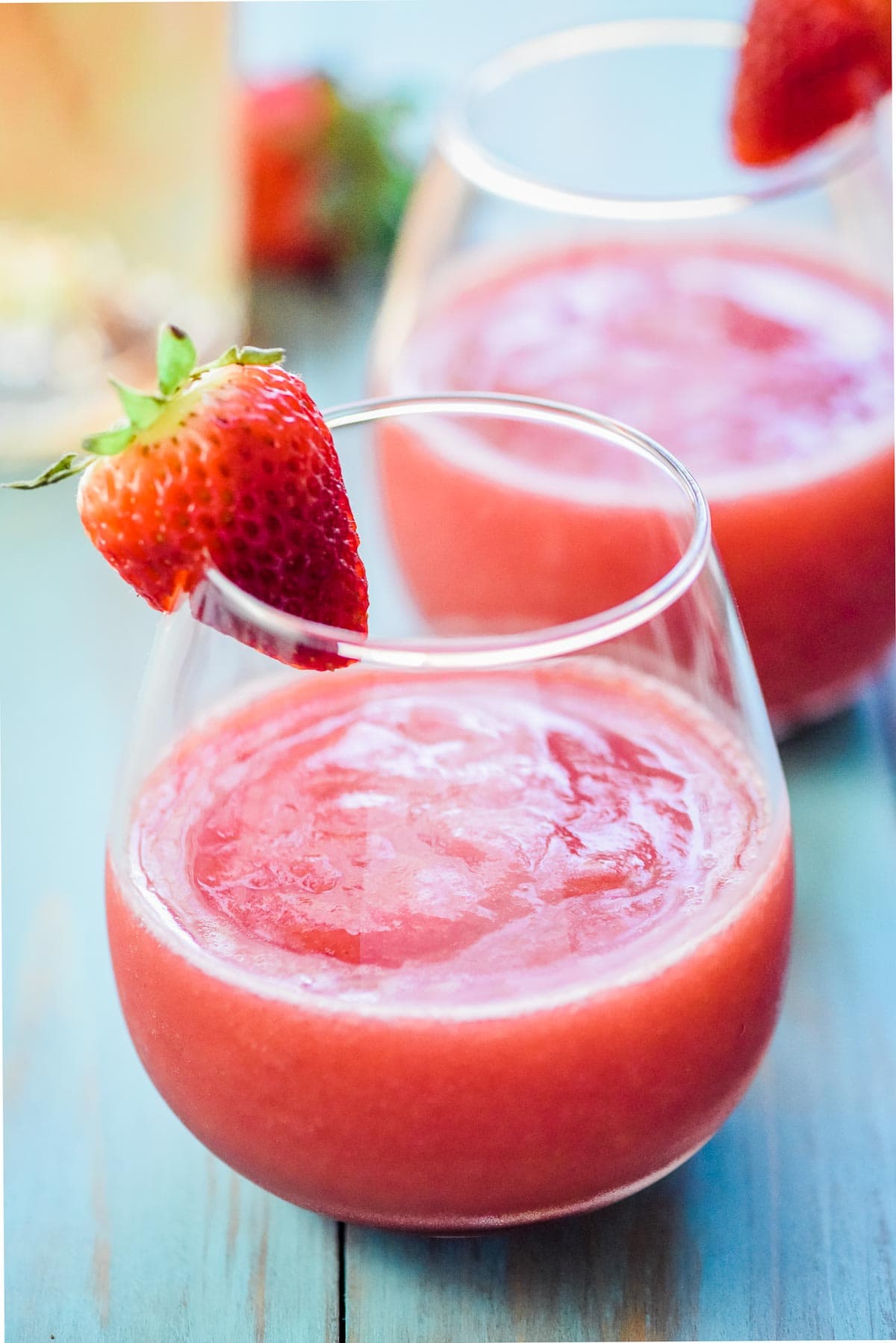 Frose in glass garnished with fresh strawberry.