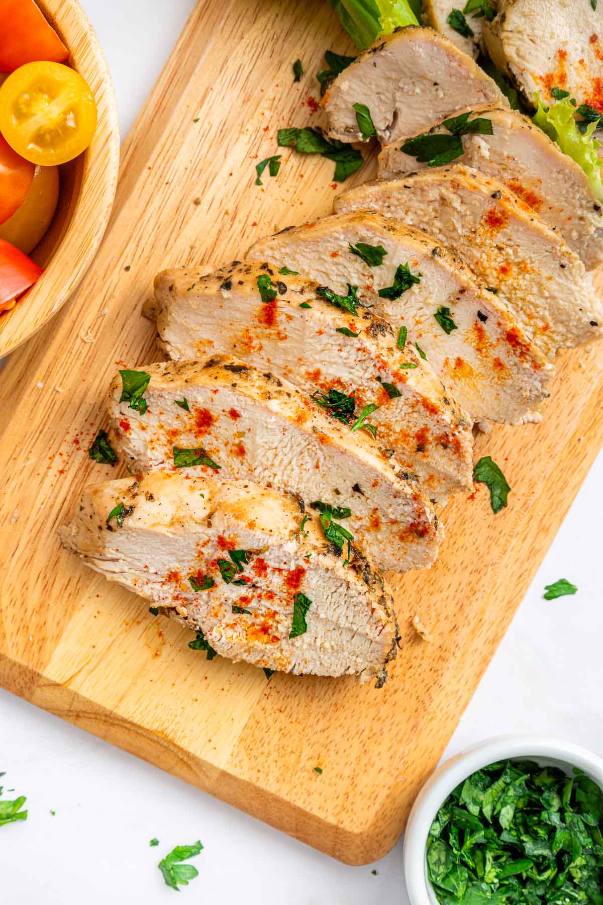 Mediterranean Chicken Marinade slices of chicken on cutting board.