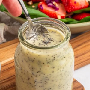 Poppy Seed Dressing dipped from jar with spoon.