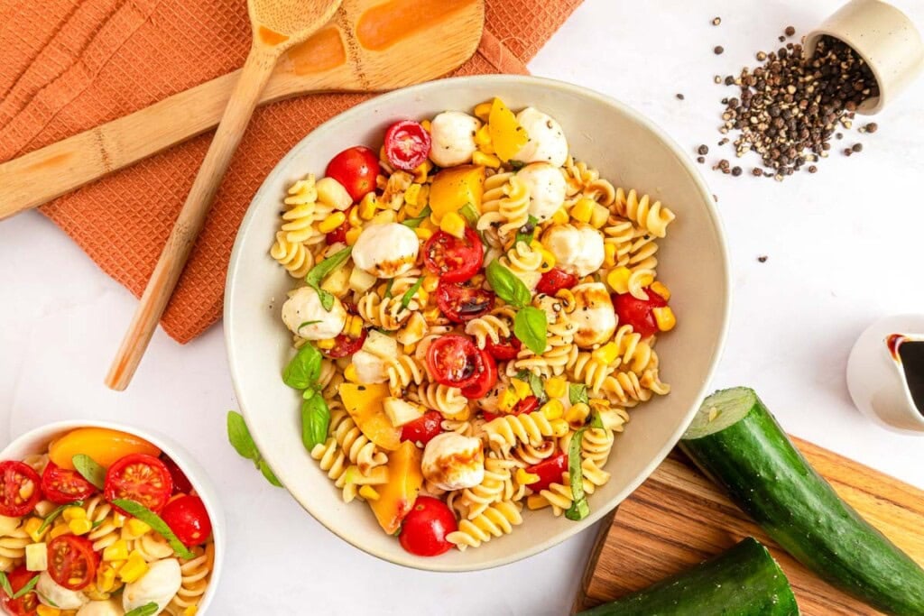 Summer Pasta Salad on table with ingredients.